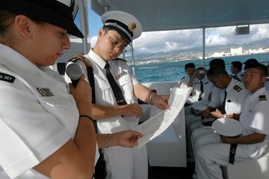 U.S. Navy SEAMAN Adriana Tirado Arreola (left), from the USS ARIZONA Memorial Detachment white boat crew, explains the history of the USN to Chinese Peoples Liberation Army Navy Sailors during their Goodwill Visit at Naval Station Pearl Harbor, Hawaii, on Sept. 7, 2006. The visit provides an excellent opportunity to enhance cooperation between the two navies and underscores the United States commitment to supporting ongoing cooperative efforts in the Pacific Region. Standing beside her is a Chinese Navy interpreter. (U.S. Navy photo by Mass Communication SPECIALIST 1ST Class James E. Foehl) (Released)