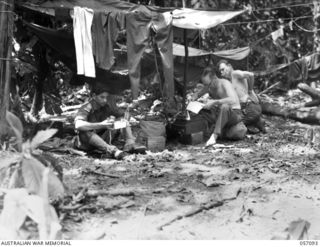 LAE, NEW GUINEA. 1943-09-19. AUSTRALIAN WAR CORRESPONDENTS, WHO LANDED WITH THE 9TH AUSTRALIAN DIVISION, QUICKLY MADE THEIR HEADQUARTERS AS NEAR TO THE FRONT LINE AS POSSIBLE. SHOWN: B204 MR ..