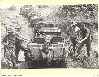 NEW GUINEA. FINSCHHAFEN AREA. NOVEMBER 1943. AFTER HEAVY RAIN MANY BRIDGES WERE WASHED AWAY IMPOSING HEAVY TASKS ON OUR TROOPS. A FERRY PONTOON IS SHOWN BEING RIGGED TO TRANSPORT JEEPS ACROSS THE ..