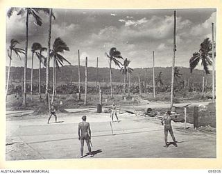 BORAM BEACH, WEWAK AREA, NEW GUINEA. 1945-08-30. MEMBERS OF HEADQUARTERS 8 INFANTRY BRIGADE TAKING PART IN A DOUBLES SET OF PAT TENNIS. THE FULL-SIZE TENNIS COURT OF BEACH AND CRUSHED CORAL WAS ..