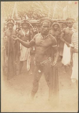 Group of men, some are wearing caps given to them by the Germans, Manus Island, Papua New Guinea, probably 1916