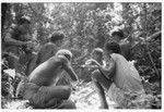 Men and boys eat a sacrificial meal in a shrine