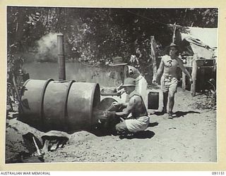 BANAK, AITAPE-WEWAK SECTOR, NEW GUINEA. 1945-04-21. COOKS OF 2/1 FIELD COMPANY, ROYAL AUSTRALIAN ENGINEERS, USING AN IMPROVISED OVEN MADE FROM A JAPANESE OIL DRUM. IDENTIFIED PERSONNEL ARE:- SAPPER ..