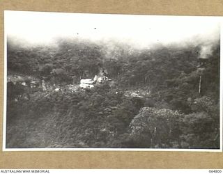 WAU, NEW GUINEA. 1944-02-11. VIEW OF THE CAMP OF THE 2/4TH FIELD SQUADRON, ROYAL AUSTRALIAN ENGINEERS TAKEN FROM THE OPPOSITE SIDE OF THE VALLEY DURING THE BUILDING OF THE NEW WAU ROAD