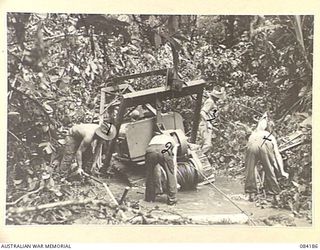 BOUGAINVILLE, SOLOMON ISLANDS. 1944-12-08. 5 AND 11 FIELD COMPANY, ROYAL AUSTRALIAN ENGINEERS SAPPERS ATTEMPTING TO DIG A BOGGED BULLDOZER FROM THE MUD. IDENTIFIED PERSONNEL ARE:- SAPPER BOWMAN, ..
