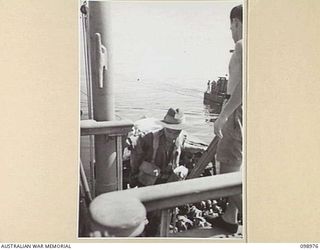 WEWAK HARBOUR, NEW GUINEA. 1945-11-25. PRIVATE C.H. PRIESTLY, 6 DIVISION, BOARDING HMAS SHROPSHIRE FOR RETURN TO AUSTRALIA FOR DISCHARGE