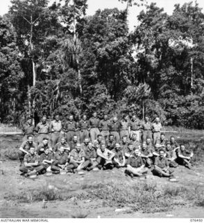 Outdoors group portrait of the personnel of the 2/8th Commando Squadron. Identified, back row, left to right: Signalman (Sig) A Hickman (27); Sig F W Wilson (28); Sig R Healey (29); Corporal (Cpl) ..