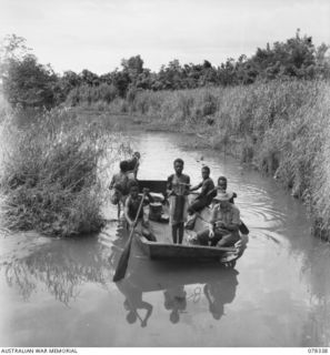 TOROKINA, BOUGAINVILLE ISLAND. 1945-01-17. NX13933 CORPORAL R.E. KLEIST, 2/1ST MALARIAL CONTROL UNIT AND HIS NATIVE ASSISTANTS USING A DDT DISPERSER WHILE TREATING STAGNANT WATER IN CREEKS AND ..