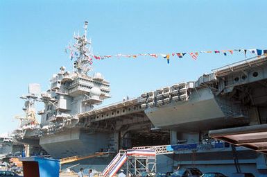 A starboard side view of the aircraft carrier USS KITTY HAWK (CV 63), decorated in full bunting for the Battle Force Seventh Fleet Change of Command Ceremony