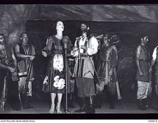 RABAUL, NEW BRITAIN, 1946-02-05. LIEUTENANT A.E. CHAPPELLE (BEPPO) AND STAFF SERGEANT E.L. STRACHAN, AUSTRALIAN WOMEN'S ARMY SERVICE, (TERESA) SINGING THEIR DUET DURING THE PLAYING OF THE MUSICAL ..