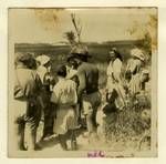 Art students in a field of wild grass, Melville Haysom back to camera at centre, North Stradbroke Island, 1949