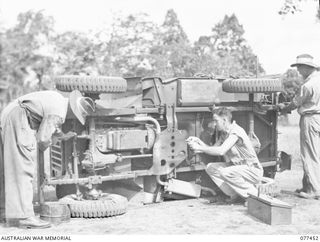 LAE BASE AREA, NEW GUINEA. 1944-12-04. PERSONNEL OF THE 2/77TH LIGHT AID DETACHMENT REPAIRING A JEEP AT THE UNIT WORKSHOP. IDENTIFIED PERSONNEL ARE:- NX25340 SERGEANT L.C. POOLE (1); NX123642 ..