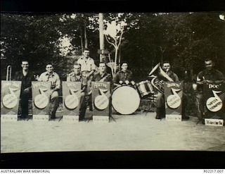 Jacquinot Bay, New Britain. 1945. Group portrait of the 36th Battalion, Australian Military Forces (AMF), swing band the "Soputa Stompers". The musicians in the front row are seated with their ..