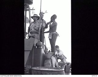 BLUP BLUP ISLAND, NEW GUINEA. 19 JUNE 1944. PRIVATE A A WOJNOWSKI, UNITED STATES ARMY (1) LIGHTS A CIGARETTE FOR A NATIVE GUIDE WHO IS DIRECTING THE UNITED STATES NAVY TORPEDO BOAT CARRYING A ..