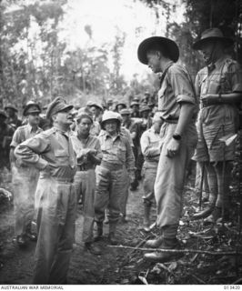 PAPUA. 1942-10-8. GENERAL DOUGLAS MACARTHUR, ON AN INSEPECTION TOUR OF THE NEW GUINEA BATTLE AREA, SPEAKS WITH AUSTRALIAN OFFICER, DON PEACOCK. (NEGATIVE BY BOTTOMLEY)