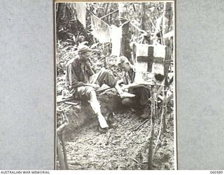 SATTELBERG AREA, NEW GUINEA. 1943-11-15. NX80381 PRIVATE W. W. BURNS BEXLEY, NT. REGIMENTAL AID POST ORDERLY OF HEADQUARTERS, 26TH AUSTRALIAN INFANTRY BRIGADE BANDAGING THE LEG OF WX4401 PRIVATE J. ..