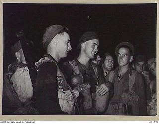 BOUGAINVILLE, 1945-05. MEMBERS OF 26 INFANTRY BATTALION (A.I.F.) AFTER A NIGHT LANDING ON TOROKORI ISLAND, WAITING TO EMBARK. THE MEN LANDED AND PATROLLED THE ISLAND SEARCHING FOR A SUSPECTED ..