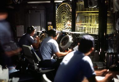 Crewmen monitor radar tracking screens aboard the amphibous assault ship USS GUAM (LPH 9)