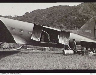 WAU, NEW GUINEA. 1943-08-08. TROOPS UNLOADING PETROL FROM A DOUGLAS C47 DAKOTA AIRCRAFT AT THE AIRFIELD