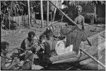 Canoe-building: carved washboard and traverse prowboard on a fishing canoe, men work on building the canoe