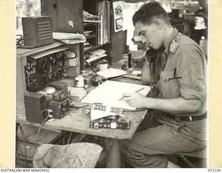 KILIGIA, NEW GUINEA. 1944-04-10. QX35571 LIEUTENANT G.H. KEITH, OFFICER- IN- CHARGE, M SECTION, (TECHNICAL MAINTENANCE) HEADQUARTERS 5TH DIVISION SIGNALS AT HIS OFFICE