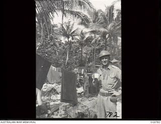 MOMOTE, LOS NEGROS ISLAND, ADMIRALTY ISLANDS. 1944-03-18. FLYING OFFICER A. STEWART, A RAAF PUBLIC RELATIONS OFFICER AND PHOTOGRAPHER, RELAXES WITH A MUG IN HIS HAND