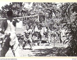 NAGADA, NEW GUINEA. 1944-08-16. MEMBERS OF E TROOP, 22ND BATTERY, 106TH TANK ATTACK REGIMENT PLAYING A GAME OF DECK TENNIS IN THE CAMP AREA. IDENTIFIED PERSONNEL ARE:- N195509 GUNNER S. DOLBEL (1); ..