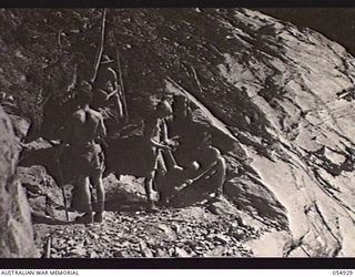 BULLDOG-WAU ROAD, NEW GUINEA, 1943-07-15. TROOPS OF THE 14TH AUSTRALIAN FIELD COMPANY, ROYAL AUSTRALIAN ENGINEERS, EDIE CREEK, CUTTING THROUGH A LARGE ROCKY OUTCROP AT THE 27 MILE POINT ON THE ..