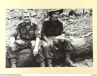 FARIA VALLEY, NEW GUINEA. 1944-02-09. SX1461 MAJOR G.R. MIETHKE, MC., (1), SECOND IN CHARGE 2/10TH INFANTRY BATTALION, PICTURED WITH THE ADJUTANT, SX1441 CAPTAIN H.R. MATHESON (2), RESTING AT MAIN ..