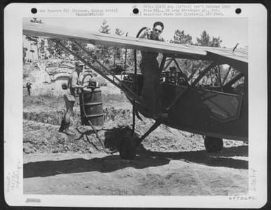 A Crane Holds The Fuselage Of A Vultee L-5 Off The Ground While Men Put The Landing Gear On The Plane. L-5's Of The 163Rd Liaison Squadron Attached To The 10Th Army, Were Dismantled And Crated At Schofield Barracks, Hawaii, For Shipment To Cub Field #7 O (U.S. Air Force Number 64726AC)