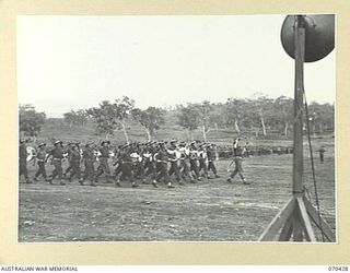 POM POM VALLEY, NEW GUINEA, 1944-02-16. THE BAND OF THE 21ST INFANTRY BRIGADE MARCH PAST THE SALUTING BASE DURING A FAREWELL MARCH. NX8 LIEUTENANT-GENERAL SIR LESLIE MORSHEAD, KCB., KBE., CMG., ..