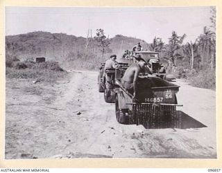 MALAGUNA, NEW BRITAIN. 1945-09-20. TROOPS OF 11 INFANTRY BATTALION, 13 INFANTRY BRIGADE, SPRINKLING THE ROAD WITH SEA WATER FROM A JEEP TRAILER TO LAY THE DUST