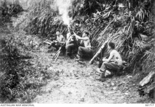 PEAK HILL, NEW GUINEA. 1943-12-10. MORTAR MEN OF THE 2/23RD AUSTRALIAN INFANTRY BATTALION ON THE ROAD AT PEAK HILL, FIRING ON JAPANESE POSITIONS ON THE WAREO-BONGA TRACK. THEY ARE: VX34472 ..