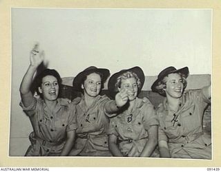 LAE, NEW GUINEA, 1945-05-07. AUSTRALIAN WOMEN'S ARMY SERVICE AWAITING THE CALL TO DISEMBARK FROM THE MV DUNTROON, CHEERING AFTER HEARING THAT MR CHURCHILL, HAD IMPORTANT NEWS. THEY ARE PART OF A ..