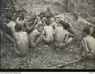 AITAPE AREA, NORTH EAST NEW GUINEA. C. 1944-04. NAKED JAPANESE PRISONERS OF WAR (POWS) CROUCH TOGETHER ON THE GROUND WHILE AWAITING TRANSPORT AFTER BEING CAPTURED BY US INVASION FORCES FOLLOWING ..