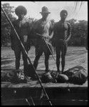 Portrait of men on boat, European man in middle holding gun