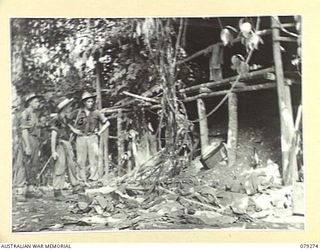 KAMANDRAN, NEW BRITAIN. 1945-02-18. TROOPS OF HEADQUARTERS, 5TH DIVISION EXAMINING A JAPANESE CAMP WHICH WAS HURRIEDLY EVACUATED A FEW HOURS PREVIOUSLY WHEN TROOPS OF THE 1ST NEW GUINEA INFANTRY ..