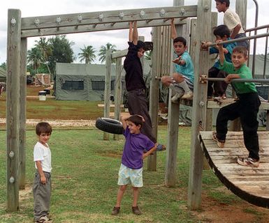 Young Kurdish refugees take advantage of the play ground at their temporary home at Anderson Air Force Base, Guam. OPERATION PACIVIC HAVEN provides airlift for some 2,700 refugees fleeing Iraq. The refugees will be housed at Anderson AFB, Guam, while they go through the immigration process for residence into the United States