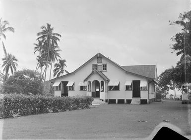 [View of a large building  with palm trees]