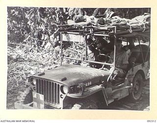 BOUGAINVILLE, 1945-05-18. A 15 FIELD COMPANY, ROYAL AUSTRALIAN ENGINEERS, JEEP AMBULANCE WITH A PRIORITY SIGN, TRANSPORTING BATTLE CASUALTIES FROM 57/60 INFANTRY BATTALION DURING THE ADVANCE SOUTH ..