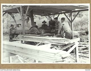 RAMU VALLEY, NEW GUINEA. 1943-12-21. PERSONNEL OF THE WORKSHOP PLATOON, 53RD AUSTRALIAN FIELD PARK COMPANY, ROYAL AUSTRALIAN ENGINEERS, 7TH AUSTRALIAN DIVISION, CUTTING TIMBER FOR BRIDGE ..