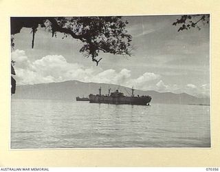 MILNE BAY, NEW GUINEA, 1944-02-10. A SCENE AT THE HEADQUARTERS, MILNE BAY BASE SUB AREA, CLOSE TO THE JAPANESE LANDING POINT IN THEIR ATTACK ON MILNE BAY 1942-08. LARGE ALLIED CARGO SHIPS NOW LIE ..