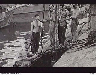 MILNE BAY, NEW GUINEA. 1943-06-29. PREPARING TO LOAD SALVAGE INTO A BARGE DURING SALVAGE OPERATIONS BY THE 2/3RD AUSTRALIAN DOCKS OPERATING COMPANY, ROYAL AUSTRALIAN ENGINEERS, AIF. LEFT TO RIGHT: ..