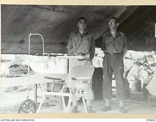 TOROKINA, BOUGAINVILLE ISLAND. 1945-02-04. TX2033 MAJOR R.O. LYONS, DENTAL OFFICER (1) AND SX10738 WARRANT OFFICER II, R.C. BILLS, DENTAL MECHANIC (2) INSIDE THE TENT SURGERY OF THE 63RD DENTAL ..