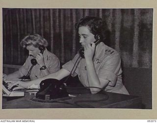 LAE, NEW GUINEA, 1945-05-20. AWAS PERSONNEL WORKING AT SIGNALS OFFICE, HQ FIRST ARMY. IDENTIFIED PERSONNEL ARE:- CORPORAL B.E. DU VE, BOOKING CLERK FOR TRUNK CALLS (1); LIEUTENANT J.I. HENNESSY, ..