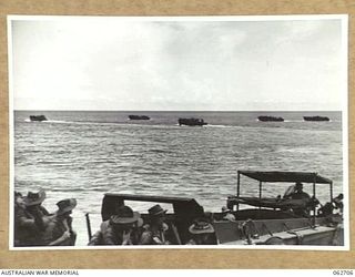 KANOMI BEACH, NEW GUINEA. 1944-01-05. TROOPS OF THE 2/23RD AUSTRALIAN INFANTRY BATTALION, 26TH AUSTRALIAN INFANTRY BRIGADE, 9TH AUSTRALIAN DIVISION BOARDING BARGES WHICH ARE TO TAKE THEM UP THE ..