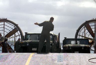 Crewmembers of the Landing Craft, Air Cushioned (LCAC) 57 offloads an M998 High-Mobility Multipurpose Wheeled Vehicle (HMMWV) on the Inner Apra Harbor, Guam, in support of Exercise TANDEM THRUST 2003