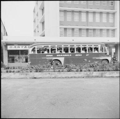 A bus travelling past a Qantas travel service shopfront, November Fiji, 1966 / Michael Terry