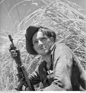 1942-12-05. NEW GUINEA. GONA. THESE AUSTRALIANS HAVE JUST COME 100 YARDS BACK FROM THE FRONT LINE FOR FOOD DURING A LULL IN THE FIGHTING. THEY ARE PART OF A COMPANY WHICH HAS BEEN 2 DAYS AND NIGHTS ..