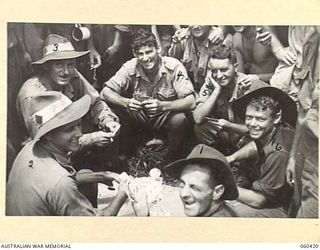 GODOWA, NEW GUINEA. 1943-11-05. TROOPS OF THE 2/6TH AUSTRALIAN FIELD REGIMENT ENJOY A GAME OF POKER WHILST AWAITING ORDERS TO MOVE. SHOWN ARE: NX21809 GUNNER E. C. HAYES OF HAY, NSW, (1); NX55881 ..